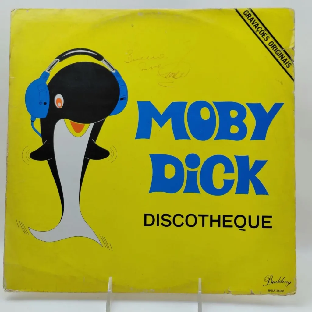 Portada de álbum Moby Dick Discotheque con ballena y auriculares sobre fondo amarillo. by Remates Narvaja