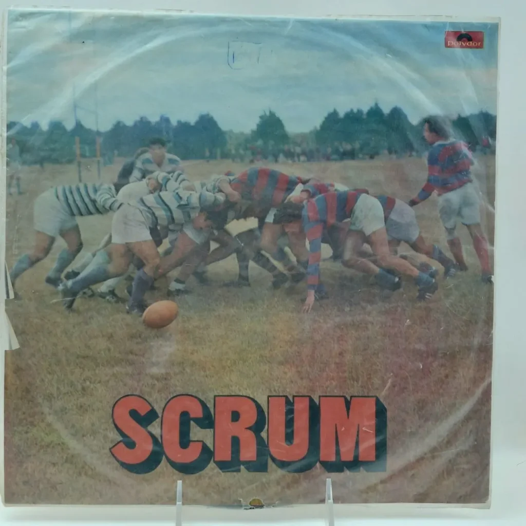 Portada de disco "Scrum" con jugadores de rugby en una melé. by Remates Narvaja