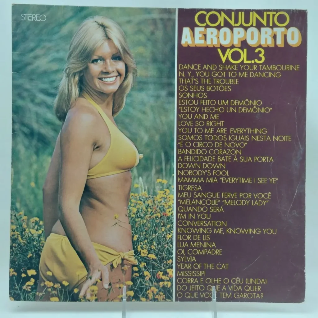 Portada del álbum Conjunto Aeroporto Vol.3 con una mujer rubia sonriente en bikini amarillo en un campo de flores, y la lista de by Remates Narvaja