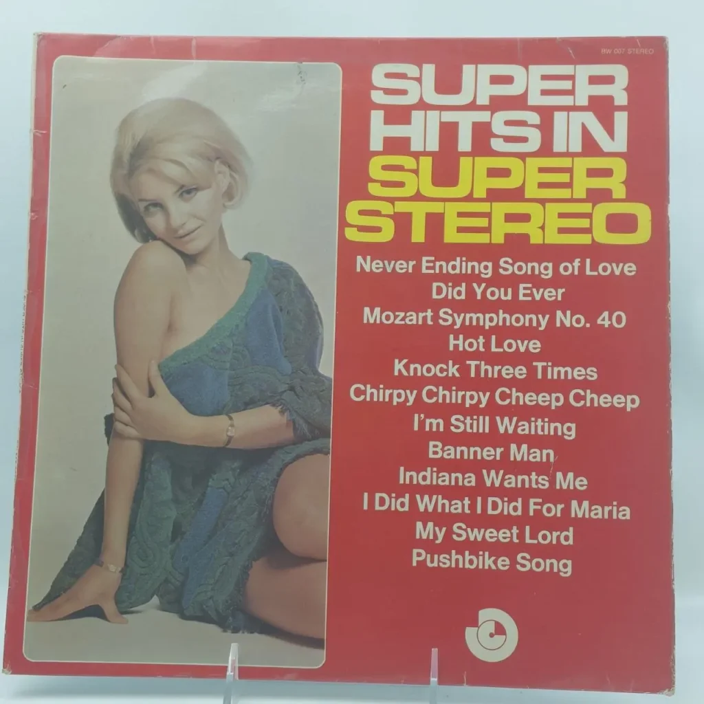 Portada de álbum de vinilo "Super Hits in Super Stereo" con mujer rubia en vestido azul/verde, fondo rojo y lista de canciones. by Remates Narvaja