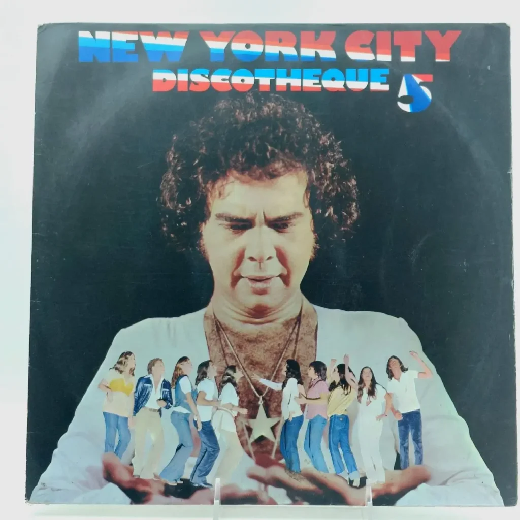 Portada de álbum de vinilo "New York City Discotheque 5" con un hombre de cabello rizado sosteniendo figuras de personas bailando. by Remates Narvaja
