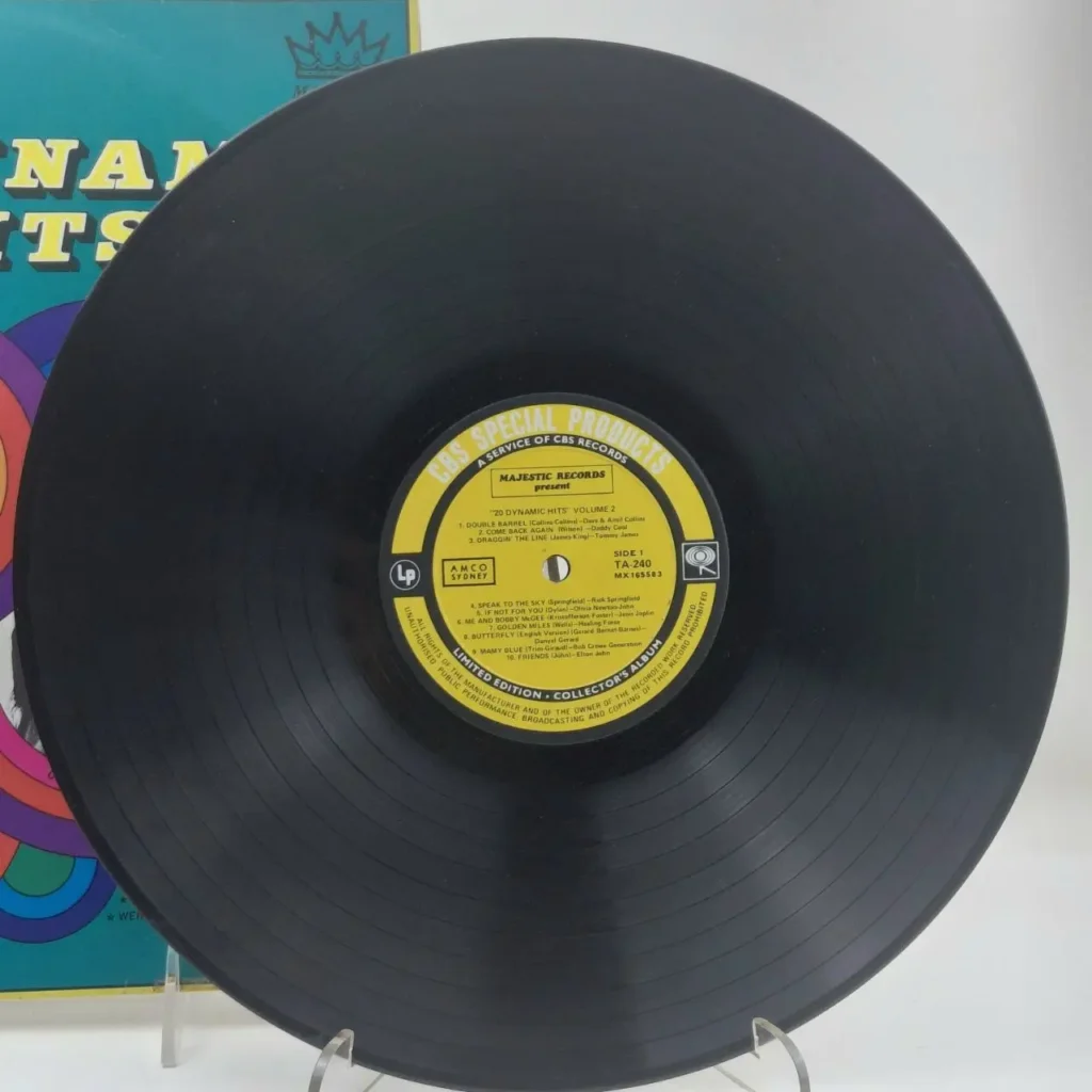 Black vinyl LP "20 Dynamic Hits Volume 2" by Majestic Records, a CBS Special Products release, with a turquoise album cover in the background. by Remates Narvaja