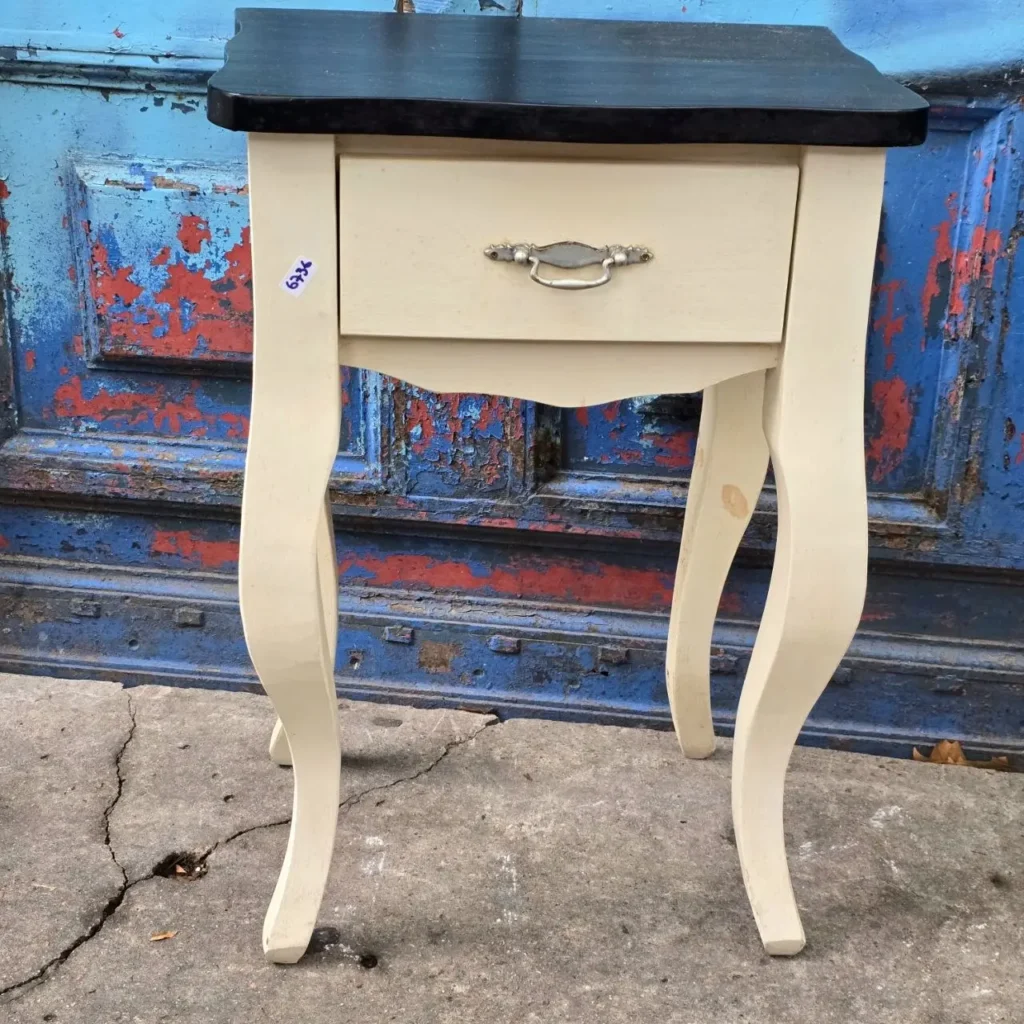 Mesita de noche crema con tapa negra, cajón y patas curvas. by Remates Narvaja