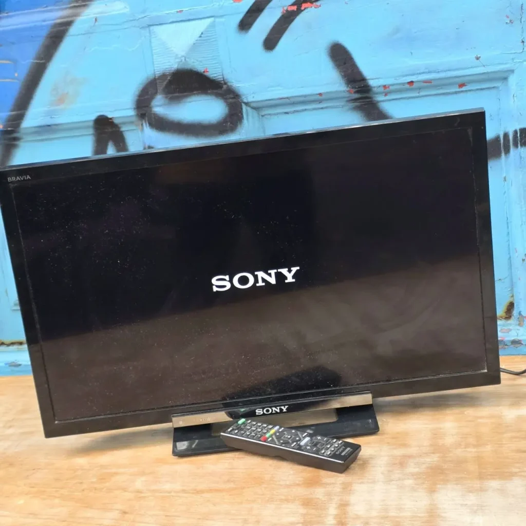 Televisor Sony Bravia negro encendido con el logo Sony y un mando a distancia. by Remates Narvaja