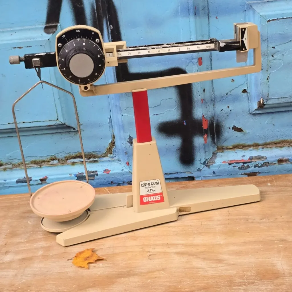 Balanza de laboratorio Ohaus Cent-O-Gram beige y roja sobre mesa de madera. by Remates Narvaja