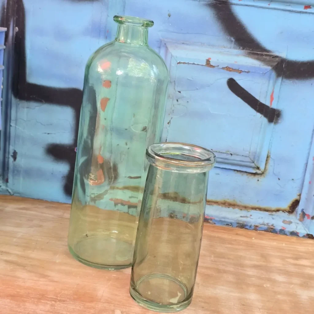 Botella de vidrio y vaso sobre madera con fondo azul rústico. by Remates Narvaja