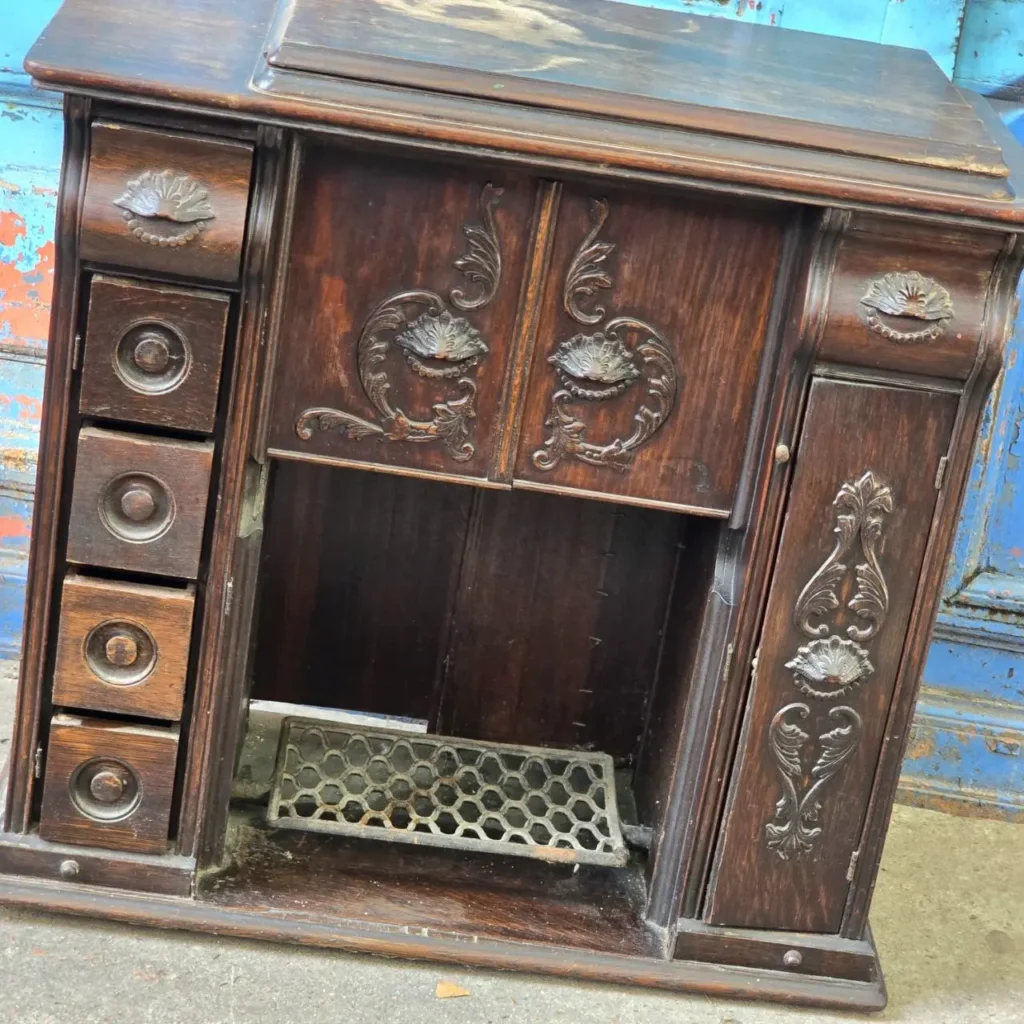 Gabinete antiguo de máquina de coser de madera oscura con tallados ornamentados y cajones. by Remates Narvaja