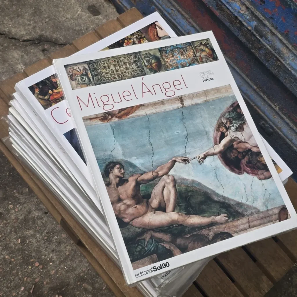 Pila de libros de arte con la portada de "La Creación de Adán" de Miguel Ángel." by Remates Narvaja