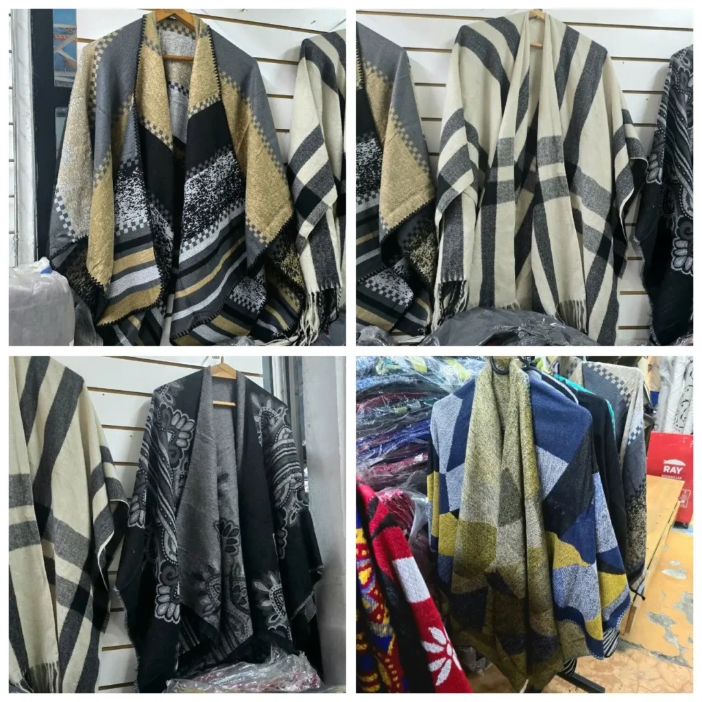 Variedad de ponchos y capas con estampados y colores diversos en una tienda de ropa. by Remates Narvaja