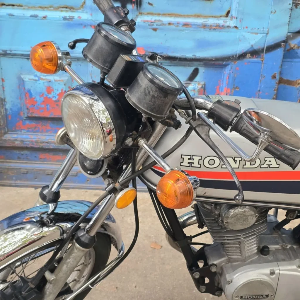 Motocicleta Honda clásica plateada con franjas rojas y azules. by Remates Narvaja