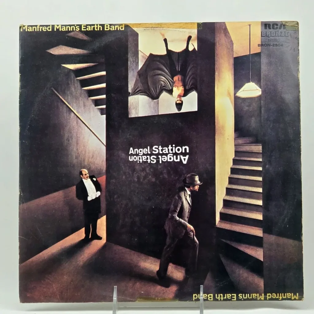 Cubierta del álbum Angel Station de Manfred Mann's Earth Band, con una escena surrealista de escaleras, hombres en traje y una figura invert by Remates Narvaja