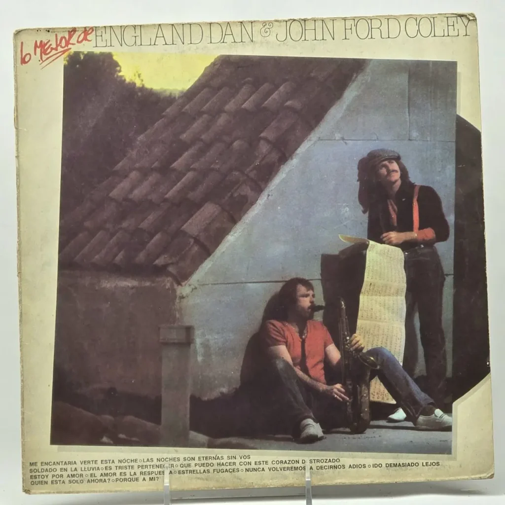 Portada del álbum "6 Mejor de England Dan & John Ford Coley" con los dos músicos, uno sentado con un saxofón y el otro de pie by Remates Narvaja