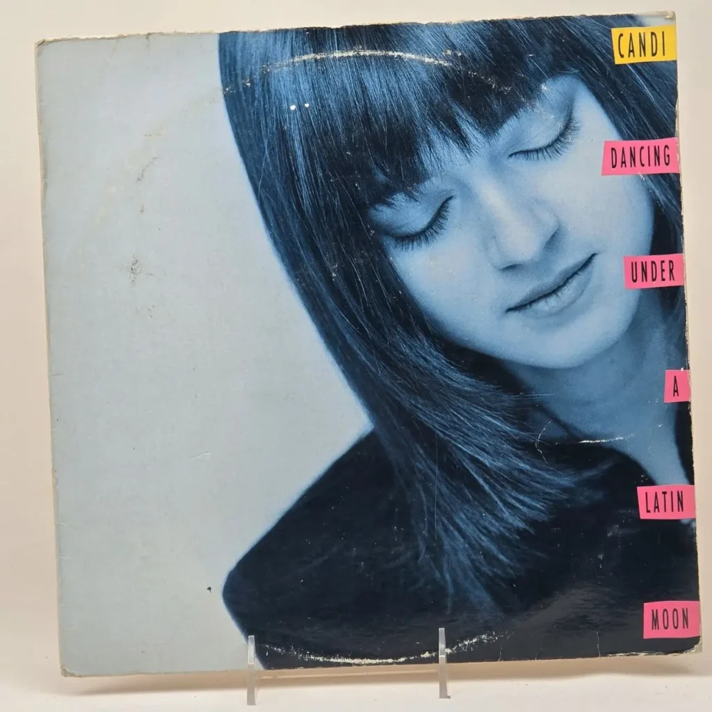 Portada del álbum Candi Dancing Under A Latin Moon con una mujer de ojos cerrados en tono azul. by Remates Narvaja
