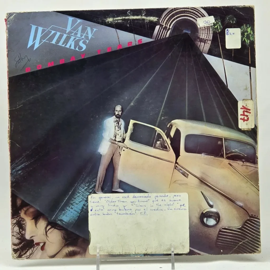 Portada del álbum "Bombay Tears" de Van Wilks con un hombre junto a un coche vintage en una carretera oscura y el rostro de una mujer by Remates Narvaja