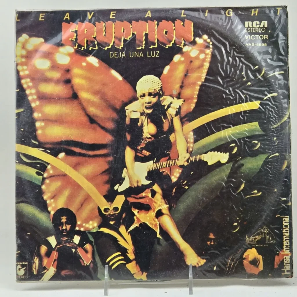 Eruption Leave a Light / Deja Una Luz album cover con cantante femenina tocando guitarra frente a un ala de mariposa brillante. by Remates Narvaja