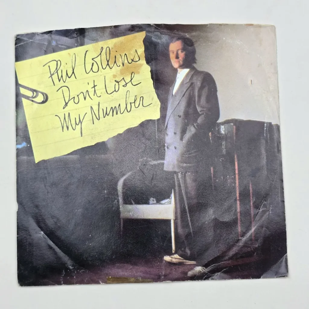 Carátula del single de Phil Collins "Don't Lose My Number" con el artista en traje y una nota amarilla. by Remates Narvaja
