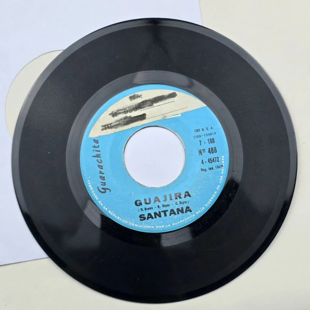 Disco de vinilo negro de 45 RPM con la canción "Guajira" de Santana en el sello azul de Guarachita. by Remates Narvaja