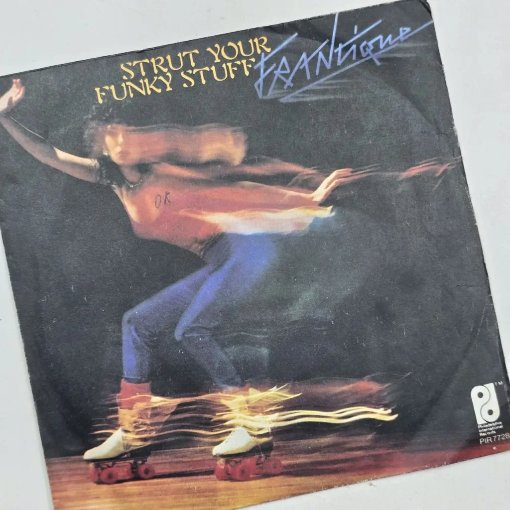Portada del single "Strut Your Funky Stuff" de Frantique, con una persona patinando sobre ruedas con efecto de movimiento. by Remates Narvaja