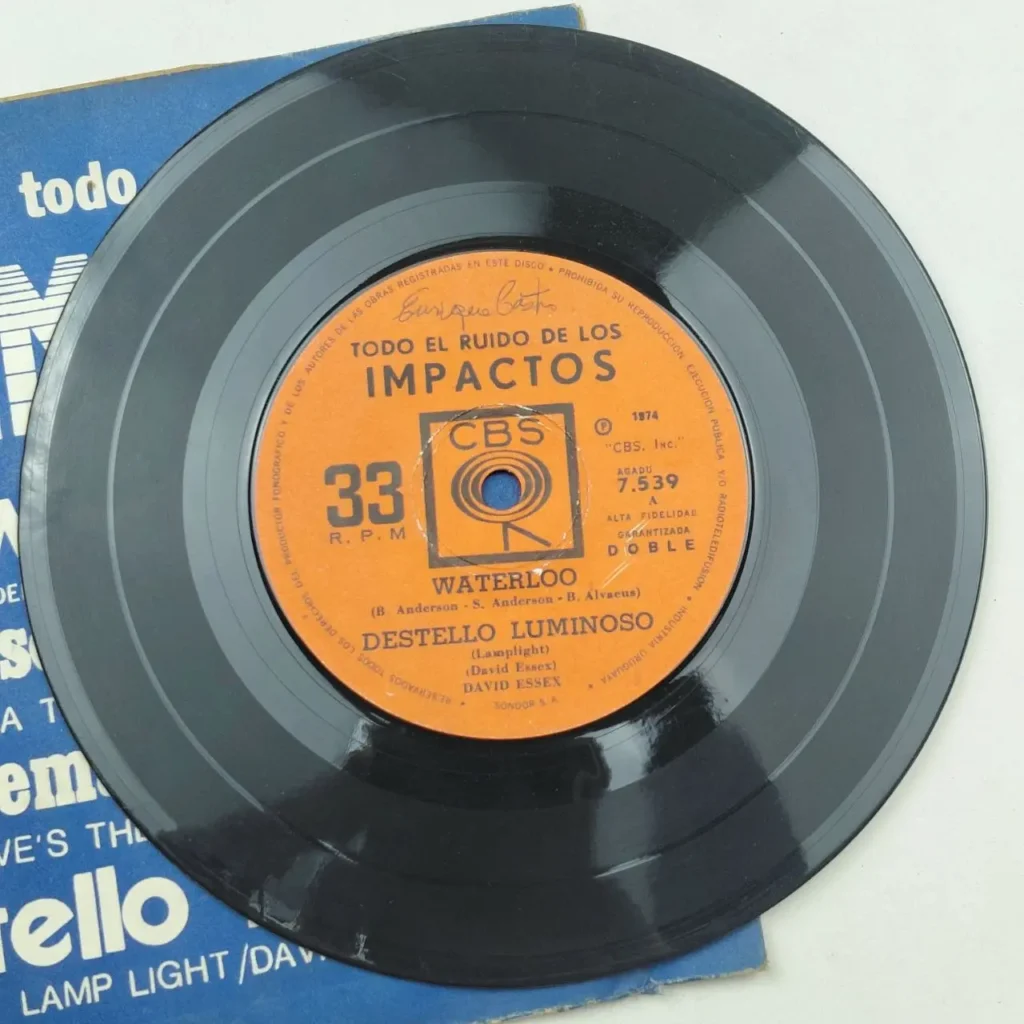Disco de vinilo negro de 1974 con etiqueta naranja CBS, presentando "Waterloo" y "Destello Luminoso (Lamplight)" by Remates Narvaja