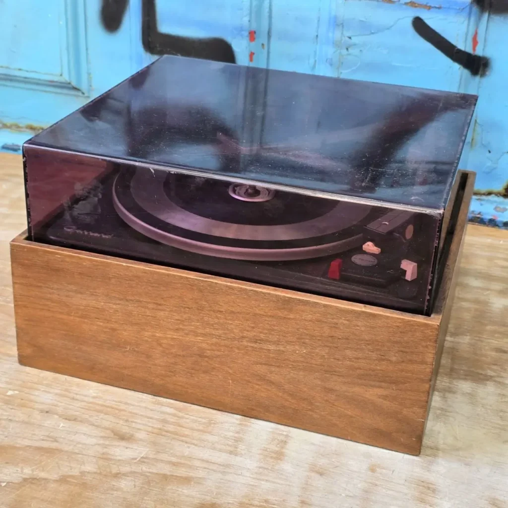 Tocadiscos vintage con base de madera y cubierta protectora oscura. by Remates Narvaja