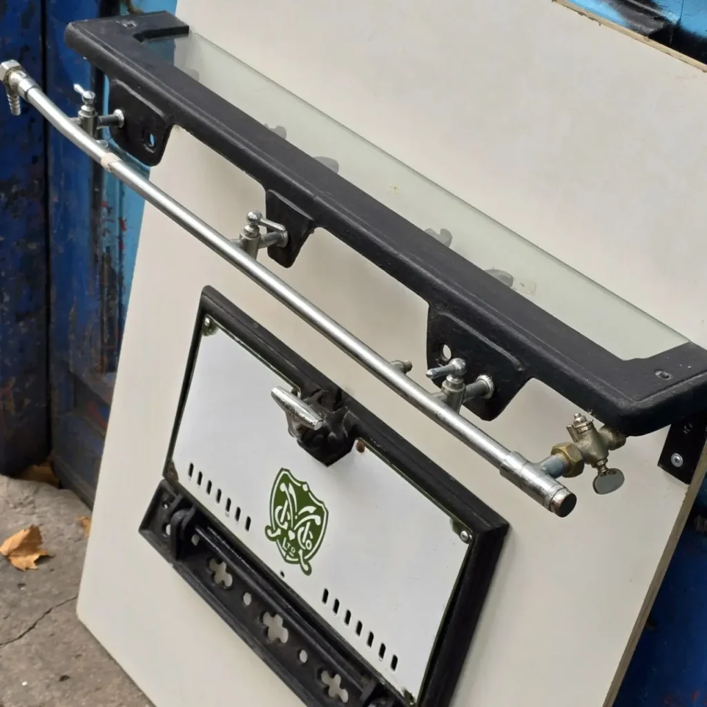 Piezas de estufa antigua: puerta de horno esmaltada, barra de gas con válvulas y marco de hierro fundido.** by Remates Narvaja