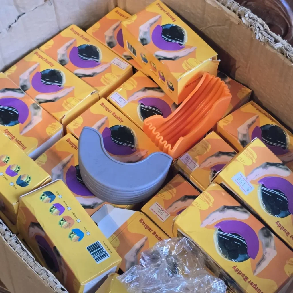 Caja llena de soportes para hamburguesas Burger Buddy en sus empaques individuales. by Remates Narvaja