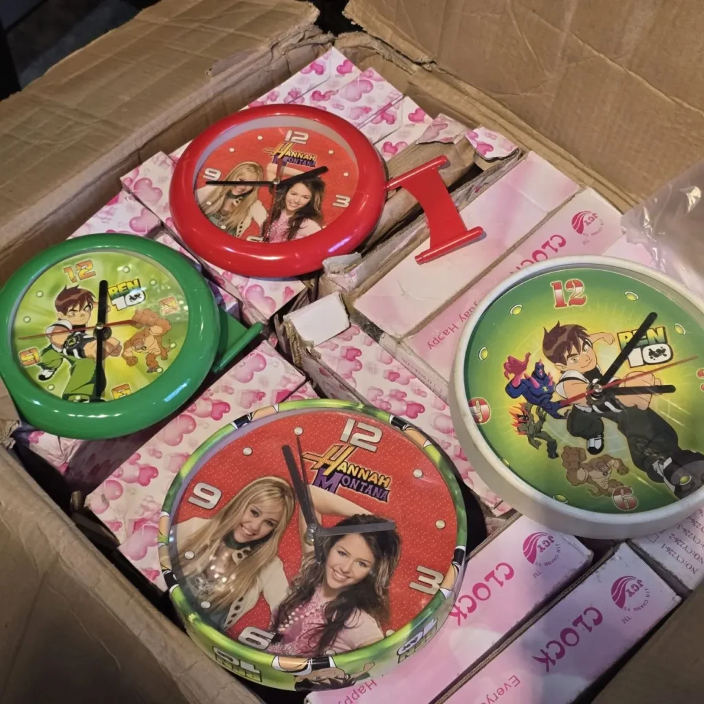 Caja de cartón llena de relojes de pared infantiles de Hannah Montana y Ben 10. by Remates Narvaja