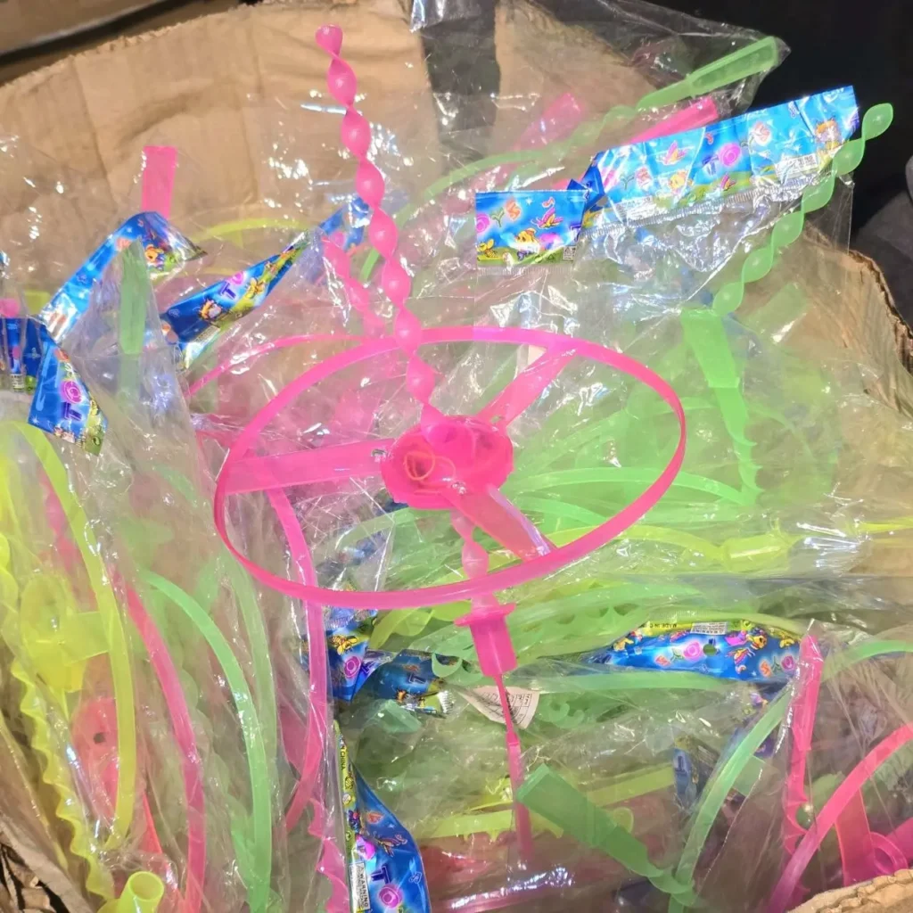 Juguetes voladores de plástico rosa y verde neón, empaquetados a granel. by Remates Narvaja