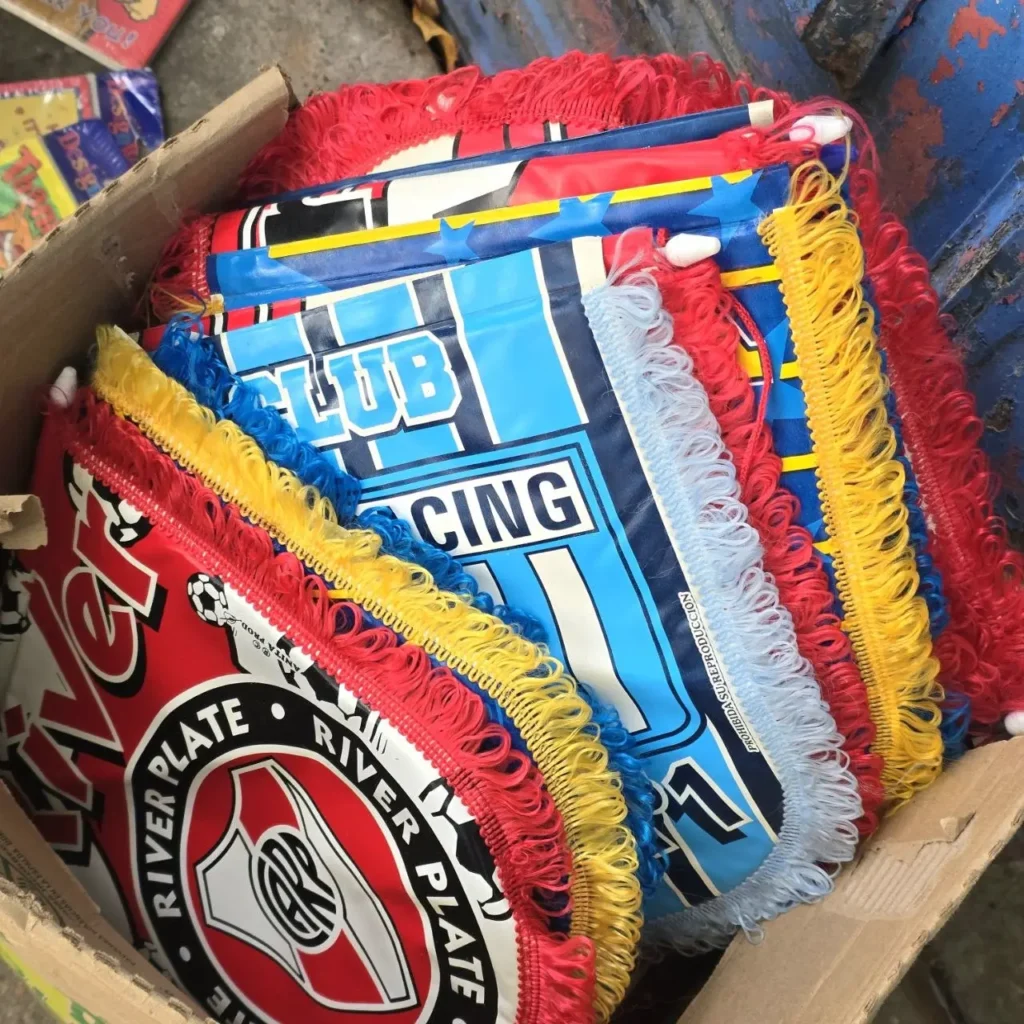 Pila de coloridos estandartes con flecos de los clubes de fútbol argentinos River Plate y Racing Club. by Remates Narvaja