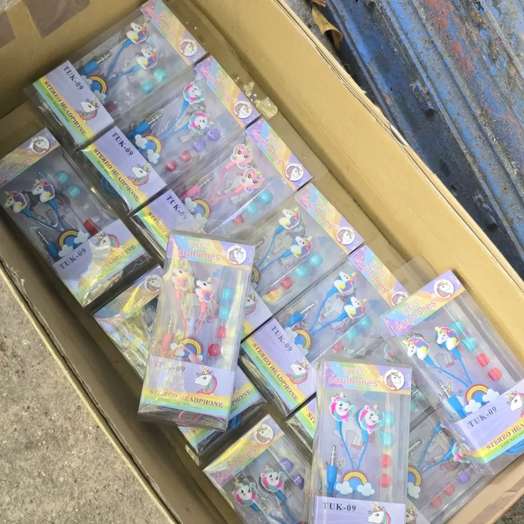 Caja llena de auriculares estéreo infantiles con diseño de unicornio y arcoíris en paquetes individuales. by Remates Narvaja