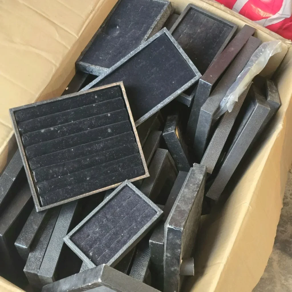 Caja de cartón con bandejas negras surtidas para exhibición de joyas, incluyendo organizadores de anillos de terciopelo. by Remates Narvaja