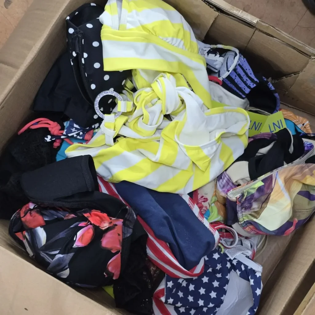 Caja llena de trajes de baño y bikinis coloridos y estampados. by Remates Narvaja