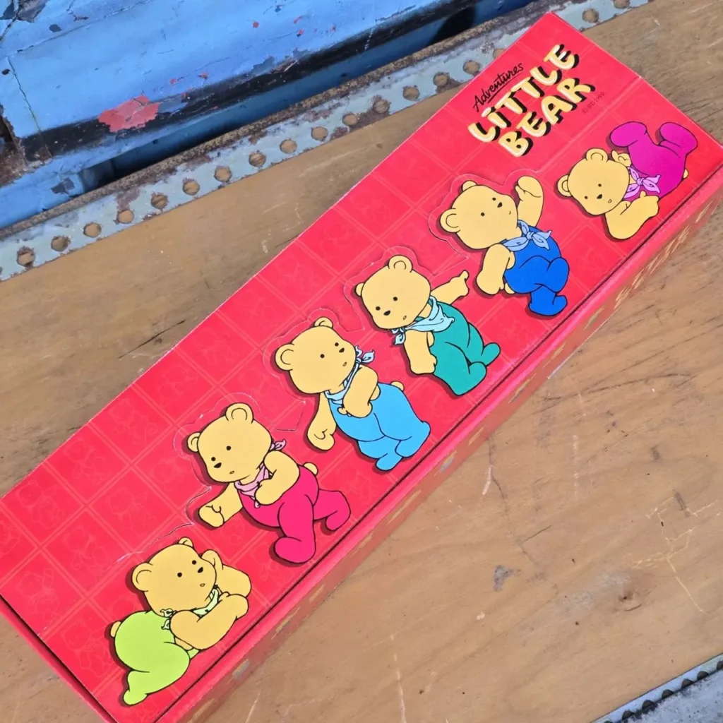 Caja roja con el título "Adventures Little Bear" y seis osos de dibujos animados en diferentes poses y ropa colorida. by Remates Narvaja