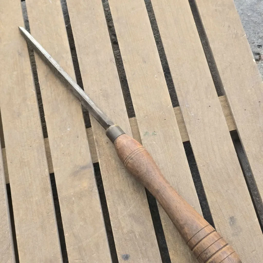 Antiguo cincel de torneado con mango de madera sobre tablas. by Remates Narvaja