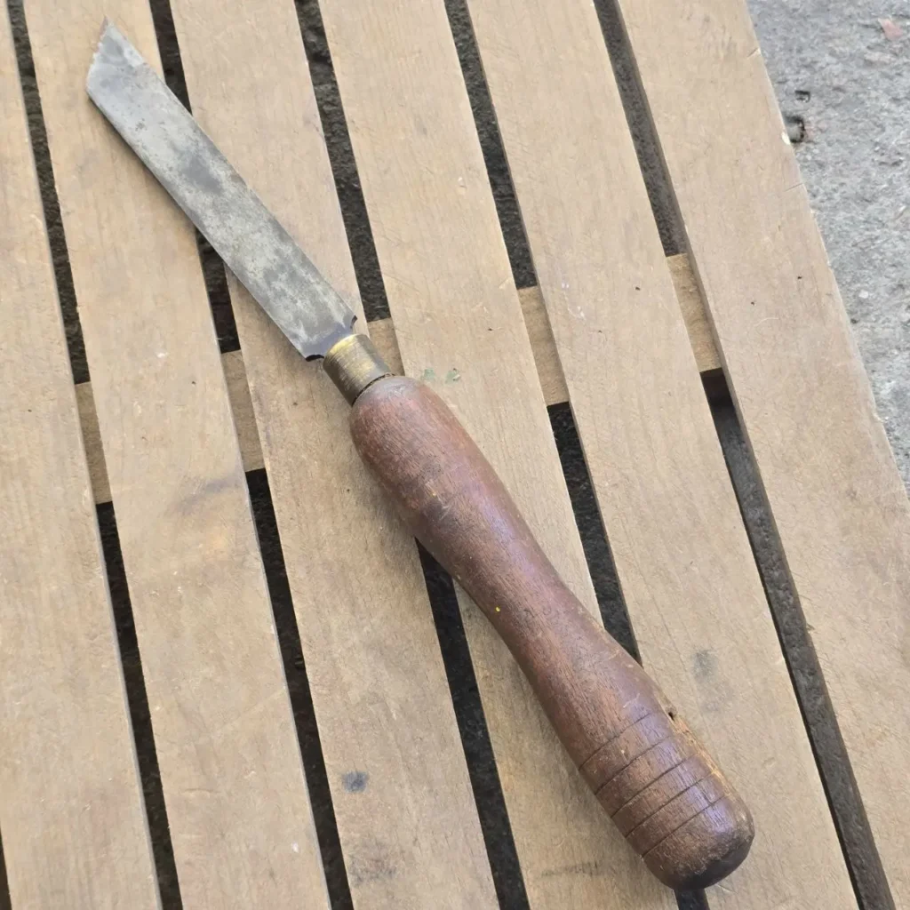 Formón antiguo de carpintería con hoja de metal y mango de madera desgastado. by Remates Narvaja