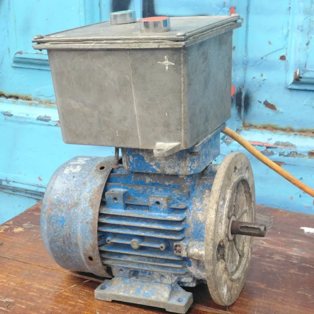 Motor eléctrico industrial azul viejo y oxidado con caja de control gris. by Remates Narvaja