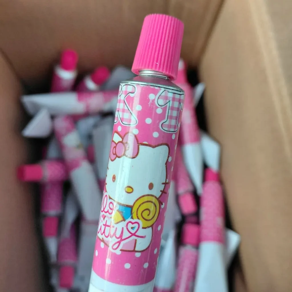 Tubo rosa de Hello Kitty con lunares y tapa rosa, en una caja con más tubos. by Remates Narvaja