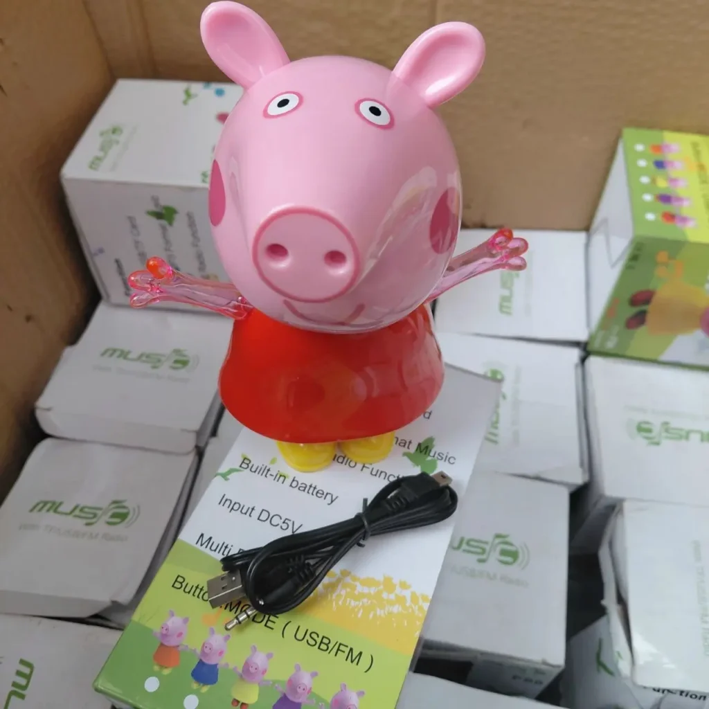 Altavoz Peppa Pig rosa con vestido rojo, cable USB y cajas de producto de radio FM. by Remates Narvaja
