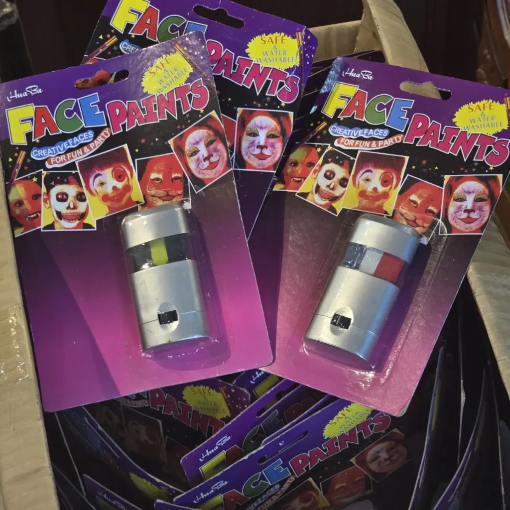 Dos kits de pintura facial Hua Ba en empaques morados, mostrando ejemplos de caras pintadas como esqueleto y gato, con aplicadores by Remates Narvaja