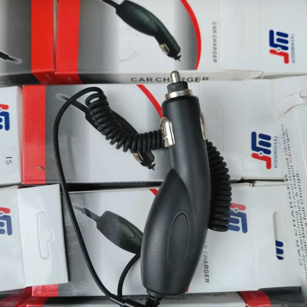 Cargador de coche negro con cable en espiral para móvil sobre cajas de producto. by Remates Narvaja
