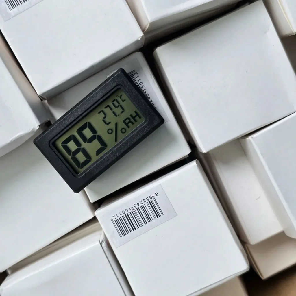 Mini termómetro e higrómetro digital sobre cajas de producto blancas. by Remates Narvaja