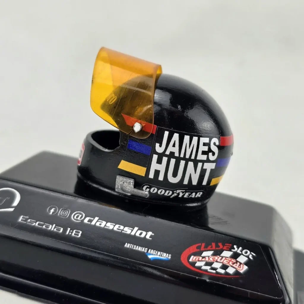 Miniatura de casco de carreras James Hunt, negro con visor naranja, escala 1:8, sobre base Clase Slot. by Remates Narvaja
