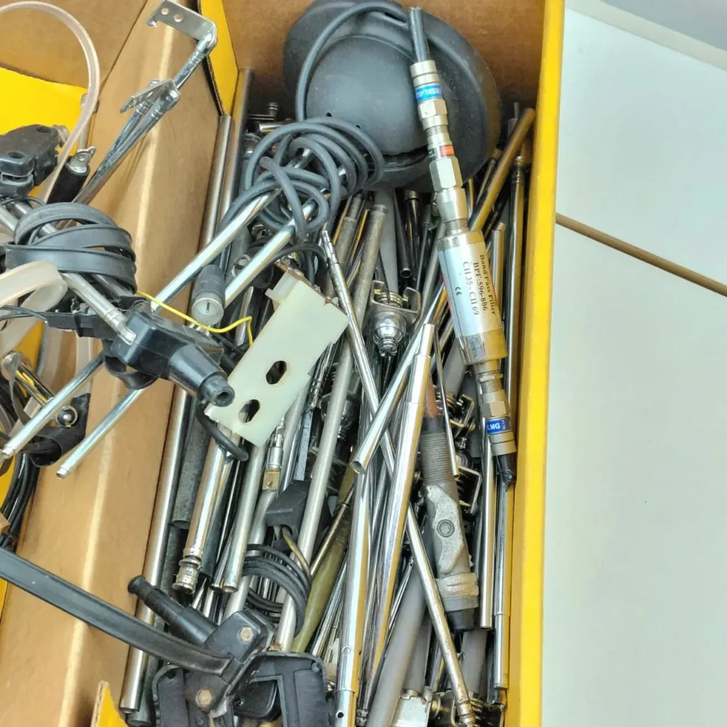 Caja llena de elementos de antena metálicos, cables y componentes de radio, incluyendo un filtro de paso de banda. by Remates Narvaja