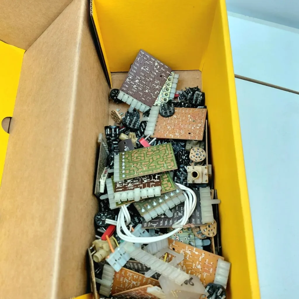 Caja llena de componentes electrónicos variados, placas de circuito y conectores. by Remates Narvaja