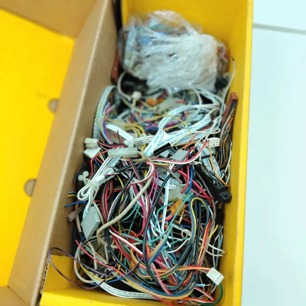Caja llena de cables electrónicos de colores variados y conectores. by Remates Narvaja