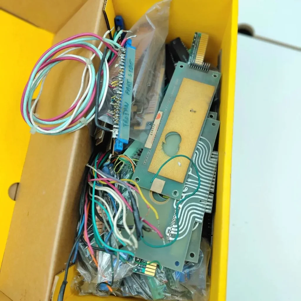 Caja amarilla con placas de circuito, cables de colores y componentes electrónicos, incluyendo un conector Thomson. by Remates Narvaja