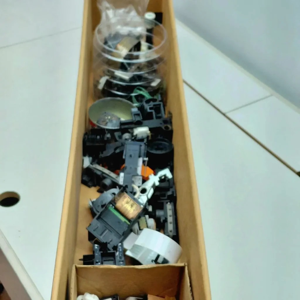 Caja de cartón con un surtido de componentes electrónicos y piezas de plástico. by Remates Narvaja