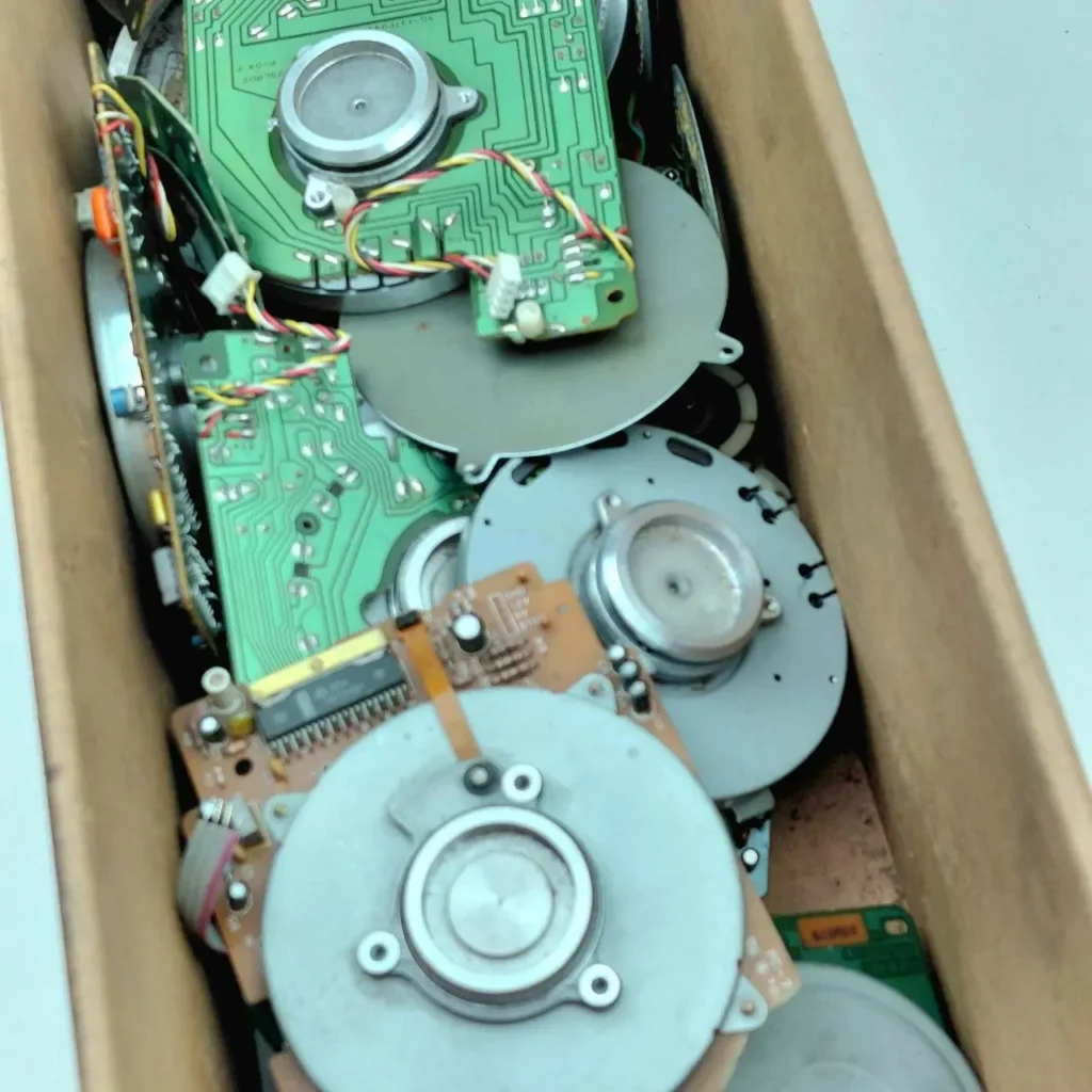 Componentes electrónicos de desecho en una caja: placas de circuito y motores para reciclaje. by Remates Narvaja