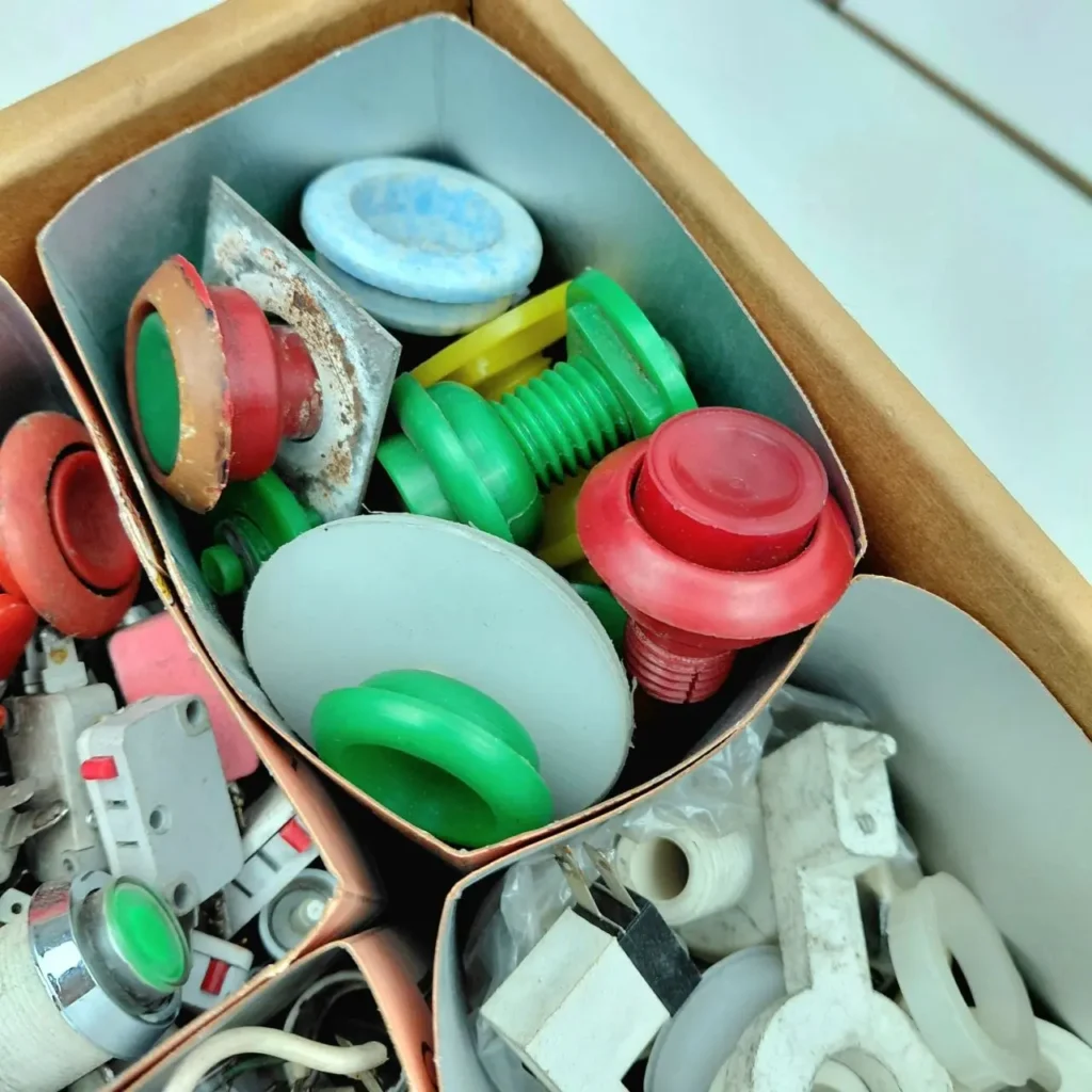 Caja con componentes electrónicos y piezas de plástico de colores variados. by Remates Narvaja