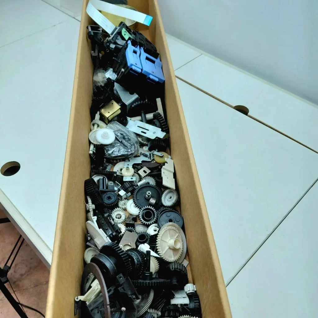 Caja llena de engranajes y componentes electrónicos variados. by Remates Narvaja
